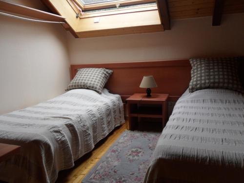 a bedroom with two beds and a skylight at Appt 4 pers-chalet l'ancienne école in La Bresse