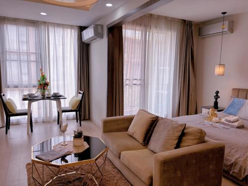 un soggiorno con letto, divano e tavolo di 45m²Cozy Room Pool Big Balcony Walk to Maya Nimman a Chiang Mai