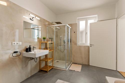 y baño con lavabo y ducha. en MT Living - private Terasse - Whirlpool, en Aschaffenburg