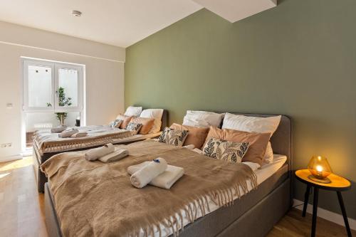 Dos camas en un dormitorio con toallas. en MT Living - private Terasse - Whirlpool, en Aschaffenburg