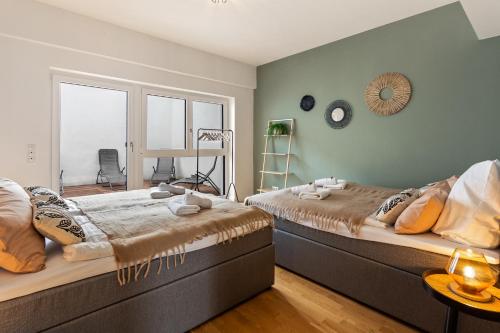 two beds in a room with a window at MT Living - private Terasse - Whirlpool in Aschaffenburg
