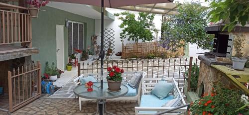 a patio with a table and chairs and an umbrella at Blue Fairytale in Ayios Nikolaos Sithonia