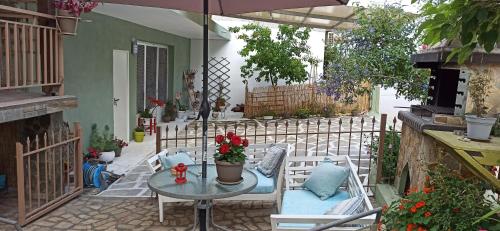 a patio with a table and chairs and an umbrella at Blue Fairytale in Agios Nikolaos