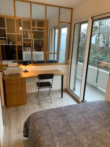 un bureau avec un bureau et une chaise dans la chambre dans l'établissement Studio avec balcon, proche de Paris tout équipé, à Asnières-sur-Seine