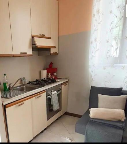 uma pequena cozinha com um lavatório e um fogão em casa silva em Monza