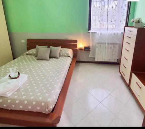 ein Schlafzimmer mit einem Bett mit einer Kommode und einem Fenster in der Unterkunft casa silva in Monza