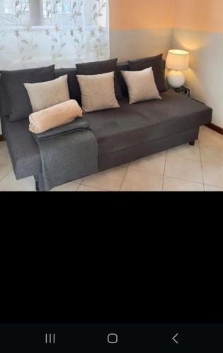 un sofá gris con almohadas en la sala de estar en casa silva, en Monza