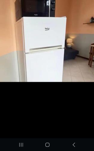 um frigorífico branco com um micro-ondas em cima em casa silva em Monza