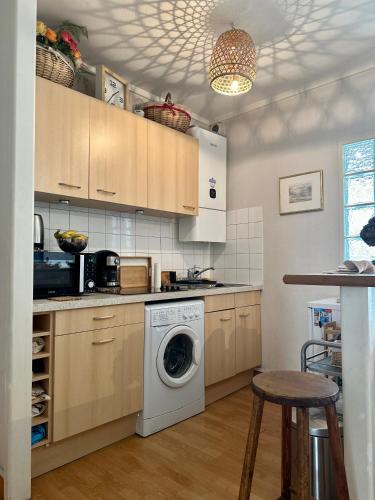 une cuisine avec une machine à laver et un lave-linge dans l'établissement bel appartement NATION, à Paris