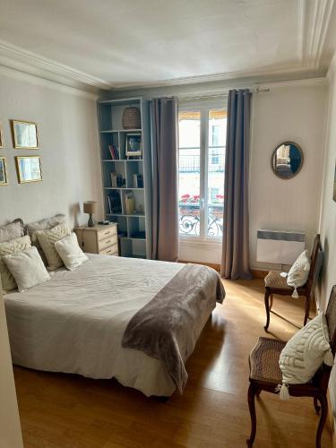 une chambre avec un grand lit et une fenêtre dans l'établissement bel appartement NATION, à Paris