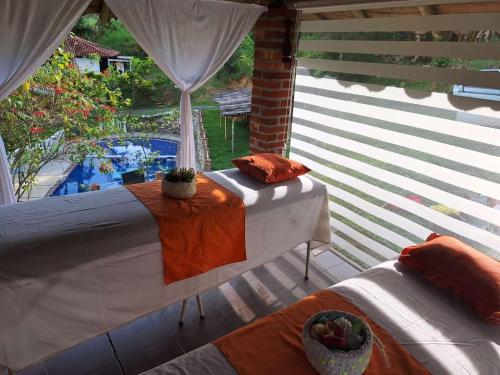 um quarto com uma cama, uma mesa e uma janela em Hotel Asturias Campestre em San Gil