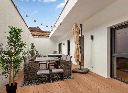 a patio with a table and chairs on a deck at MT Living - private Terasse - Whirlpool in Aschaffenburg