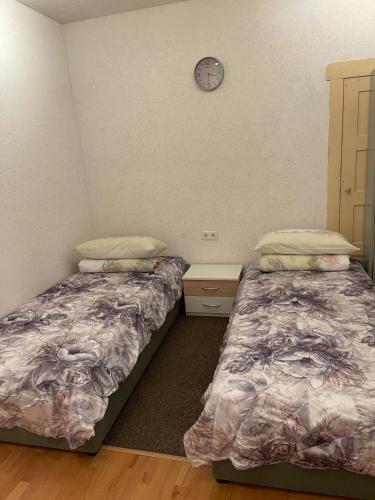 2 camas en una habitación con un reloj en la pared en willana en Schönebeck