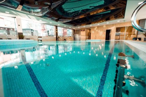 una piscina con agua azul en un edificio en Rewal Red Sun Morska, en Rewal