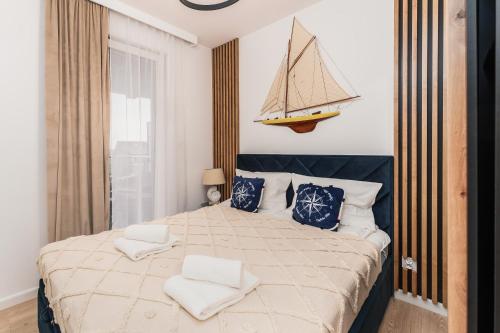 Un dormitorio con una cama grande con un barco en la pared. en Rewal Red Sun Morska, en Rewal