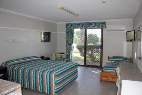 une chambre d'hôtel avec deux lits et un balcon dans l'établissement Ningaloo Coral Bay – Bayview, à Coral Bay