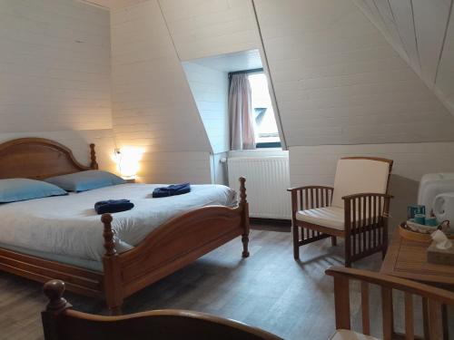 una camera con un letto e una sedia e una finestra di Chambres d'hôtes L'Oustal a Oloron-Sainte-Marie