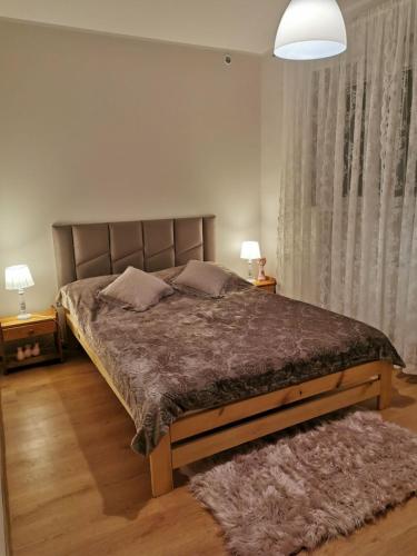 a bedroom with a large bed with two pillows at Apartament Poranek in Grzybowo