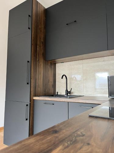 a kitchen with white cabinets and a sink and a counter at Residence 25V in Batajnica