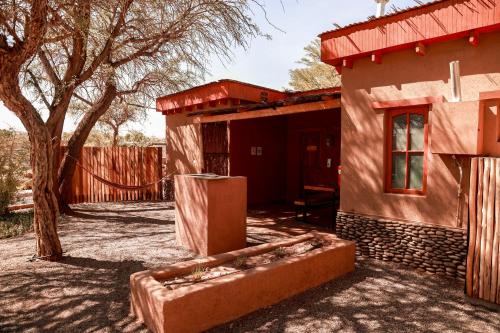 a small house with a tree and a fence at Tambo Atacama Lodge in San Pedro de Atacama