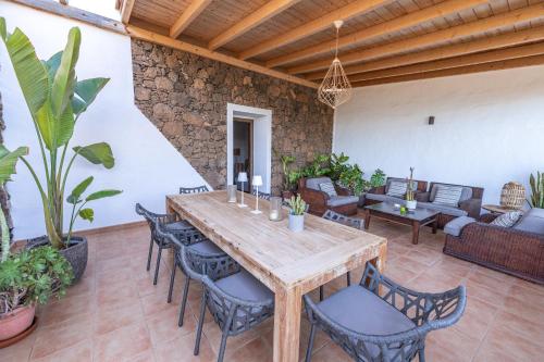 an outdoor patio with a wooden table and chairs at Casa Alexis - La Fuentita in Tuineje