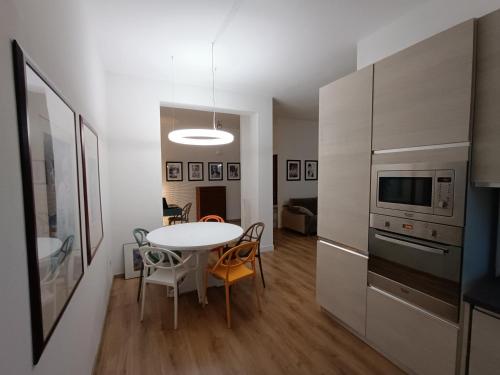 una cucina con tavolo e una cucina con frigorifero di Rifugio a Metanopoli con cucina attrezzata a San Donato Milanese