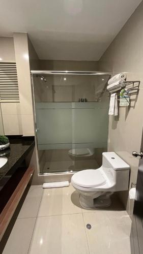 a bathroom with a toilet and a glass shower at Hotel El Tambo 2 in Lima