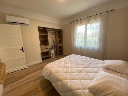 une chambre avec un lit blanc et une fenêtre dans l'établissement Villa détente jacuzzi, à Saint-Étienne-de-Fougères