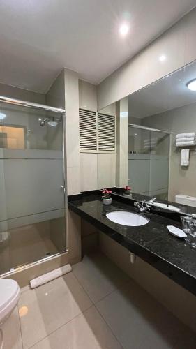 a bathroom with a sink and a shower and a toilet at Hotel El Tambo 2 in Lima