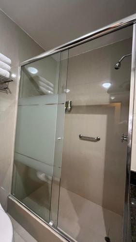 a shower with a glass door in a bathroom at Hotel El Tambo 2 in Lima