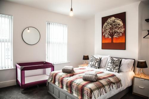 a bedroom with a bed and a tree picture on the wall at MantonHouse by Sheryl - Sleeps 7 in Liverpool