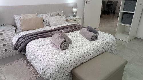 a bedroom with a large bed with towels on it at FUENGIROLA CENTRO in Fuengirola
