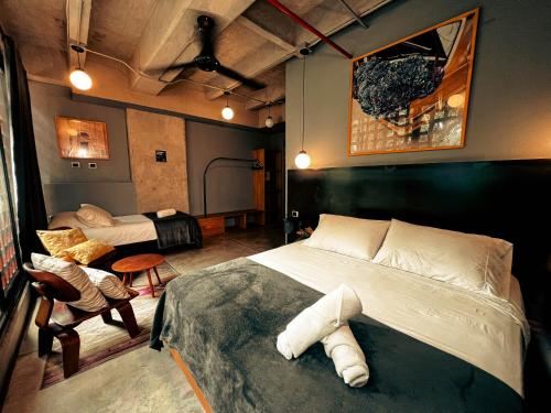 um quarto com uma cama, um sofá e uma cadeira em Viajero Medellin Hostel em Medellín