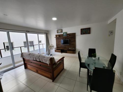 sala de estar con sofá y mesa de cristal en Quadra mar- Apto 2 quartos com ar!, en Arraial do Cabo