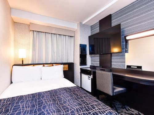 Cette chambre comprend un lit et un bureau. dans l'établissement APA Hotel Niigata Higashinakadori, à Niigata