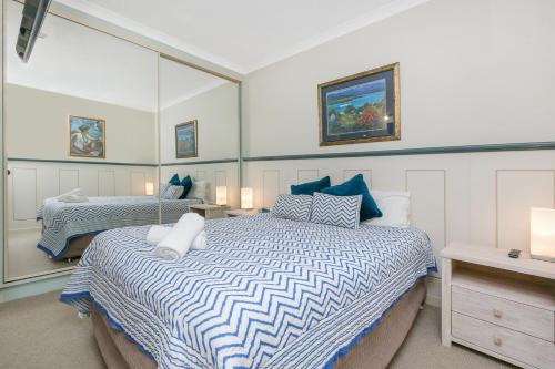 a bedroom with two beds and a mirror at Argyle on the Park in Maroochydore