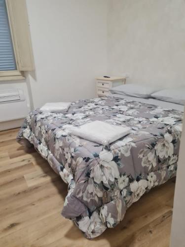 a bedroom with a bed with a floral blanket at AFFITTA CAMERE MAZZATINTI in Gubbio