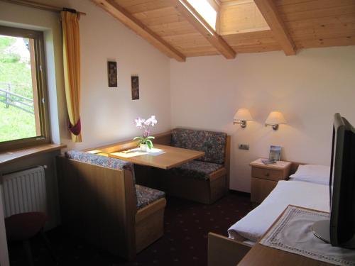 a hotel room with a bed and a table and chairs at Garni Sonneck in Laion