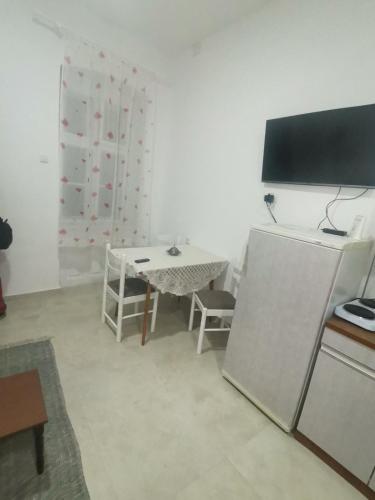 a living room with a table and a refrigerator at T.I.M.2 in Bela Crkva