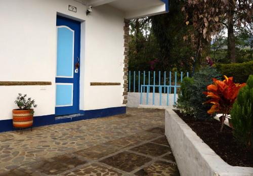 a house with a blue door and a fence at Vista Farallones Hostel in Jardin