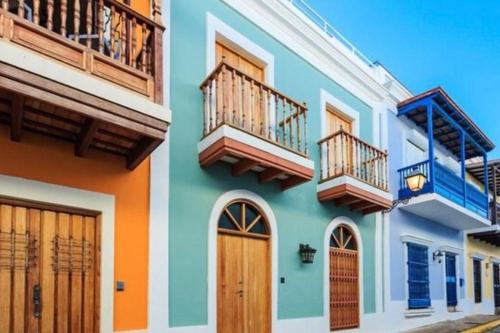 a colorful house with balconies and doors on a street at Fiesta Spot at La Placita in San Juan