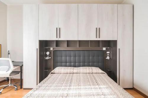 1 dormitorio con 1 cama con armarios blancos y escritorio en Como 101, centro città, en Como