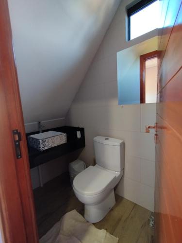 a bathroom with a white toilet in a attic at Ñande renda in Ciudad del Este