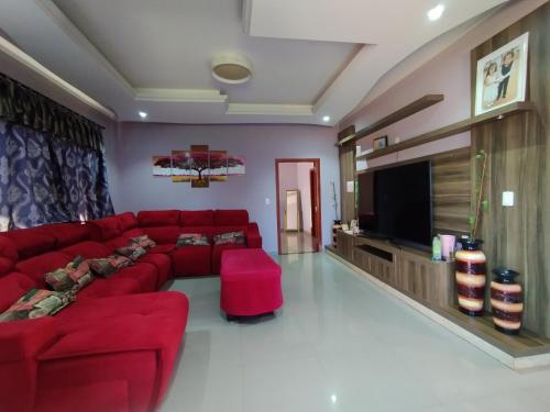 sala de estar con sofá rojo y TV de pantalla plana en Ñande renda en Ciudad del Este