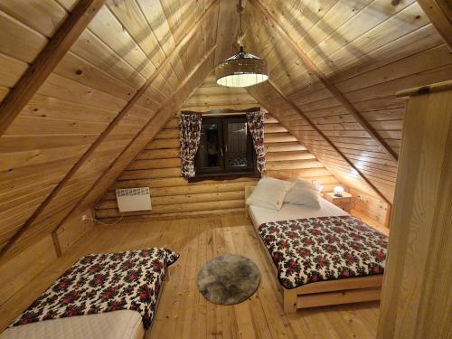 a bedroom in a log cabin with two beds at Chaty pod Pilskiem - Krzyżówki - Korbielów in Krzyżowa