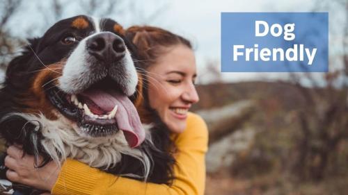 a woman holding a dog with the words dog friendly at Mountaintop Views, Hot Tub, Deck, Fire Pit & WiFi in Augusta