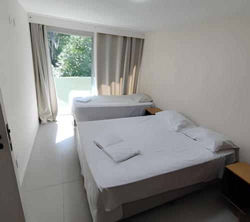 Duas camas num quarto com uma janela em Apartamento Top Garagem Feirinha e Hospitais em São Paulo