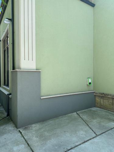 a corner of a building with a door and a wall at Пространства за гости Синият час - апартамент The Glass Moon in Ruse