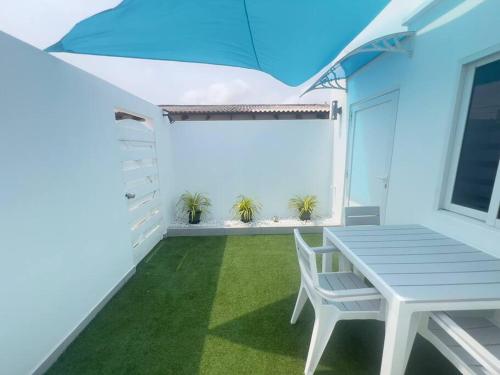 a white patio with a white bench and plants at Paradise Studio Aruba in Palm-Eagle Beach