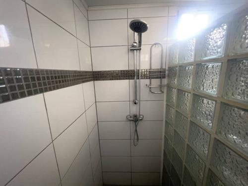 a shower in a white tiled bathroom at Paradise Studio Aruba in Palm-Eagle Beach